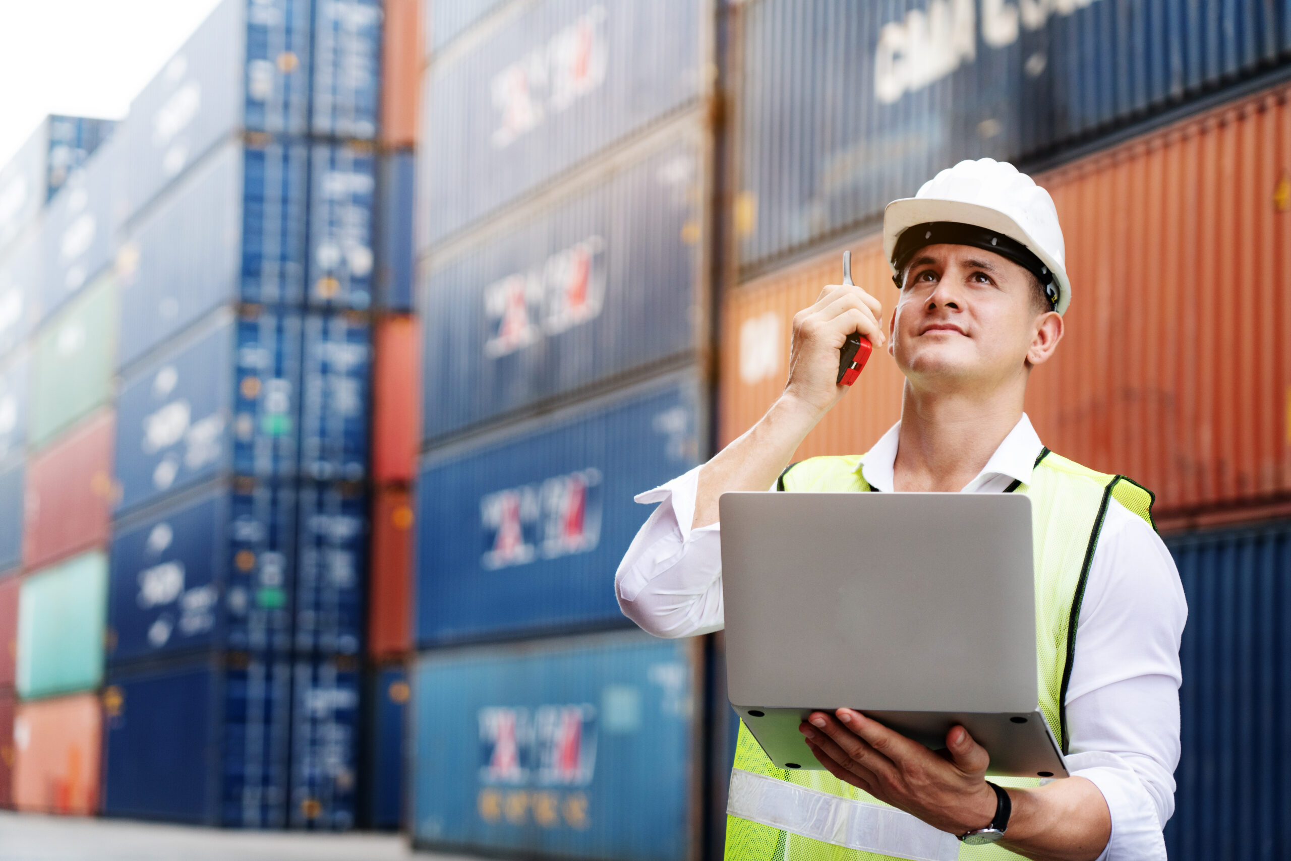 Engineer or foreman use walkie-talkie and laptop.